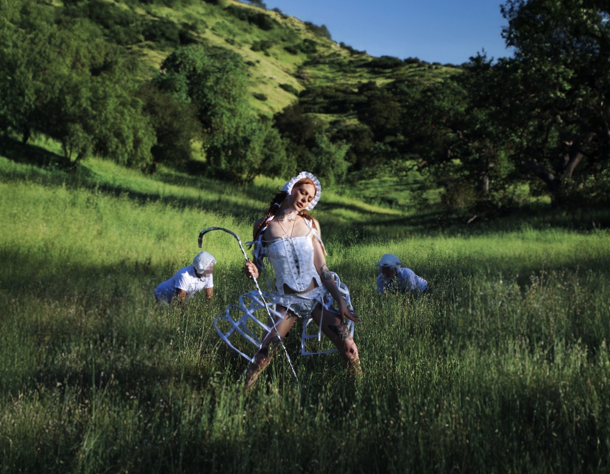 Mistress Luna in white shepherdess styling in a wide pastoral field